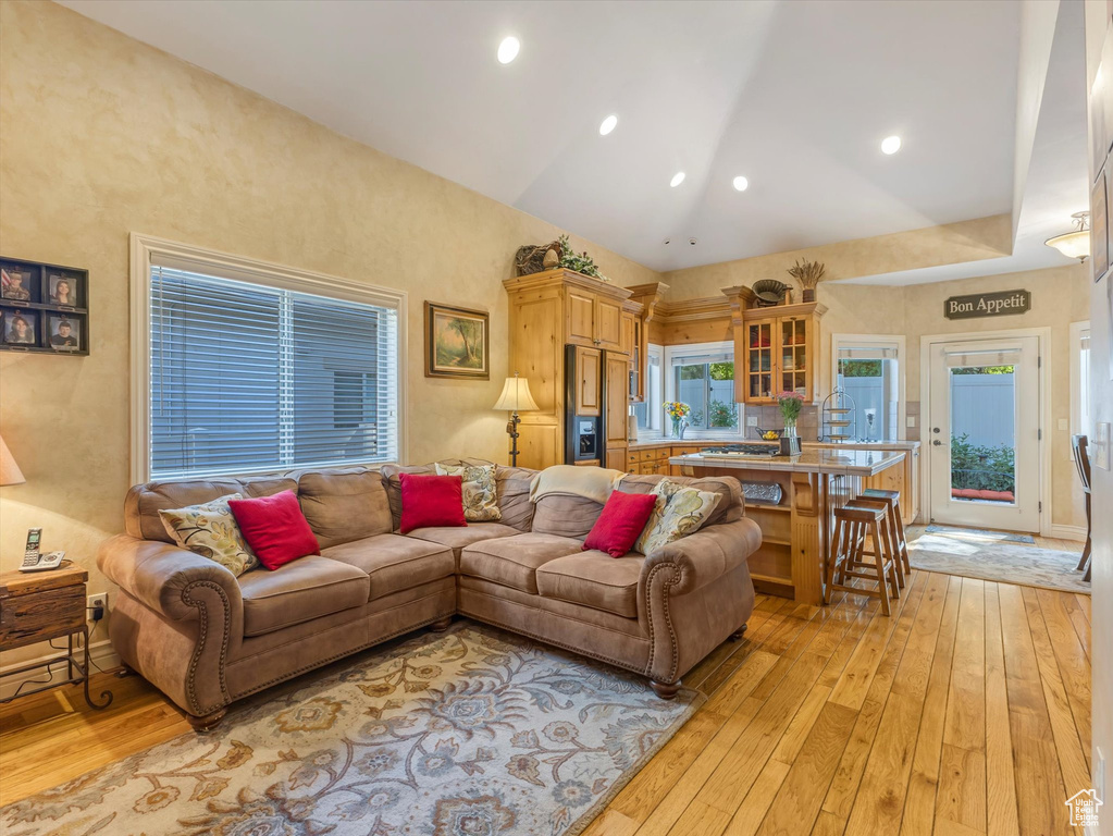 Living area with light wood-style flooring and vaulted ceiling