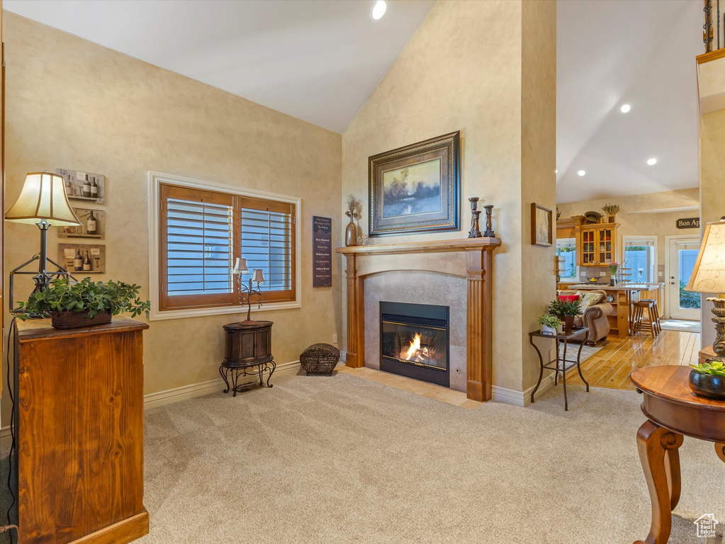 Living area with lofted ceiling, carpet, a fireplace, and recessed lighting