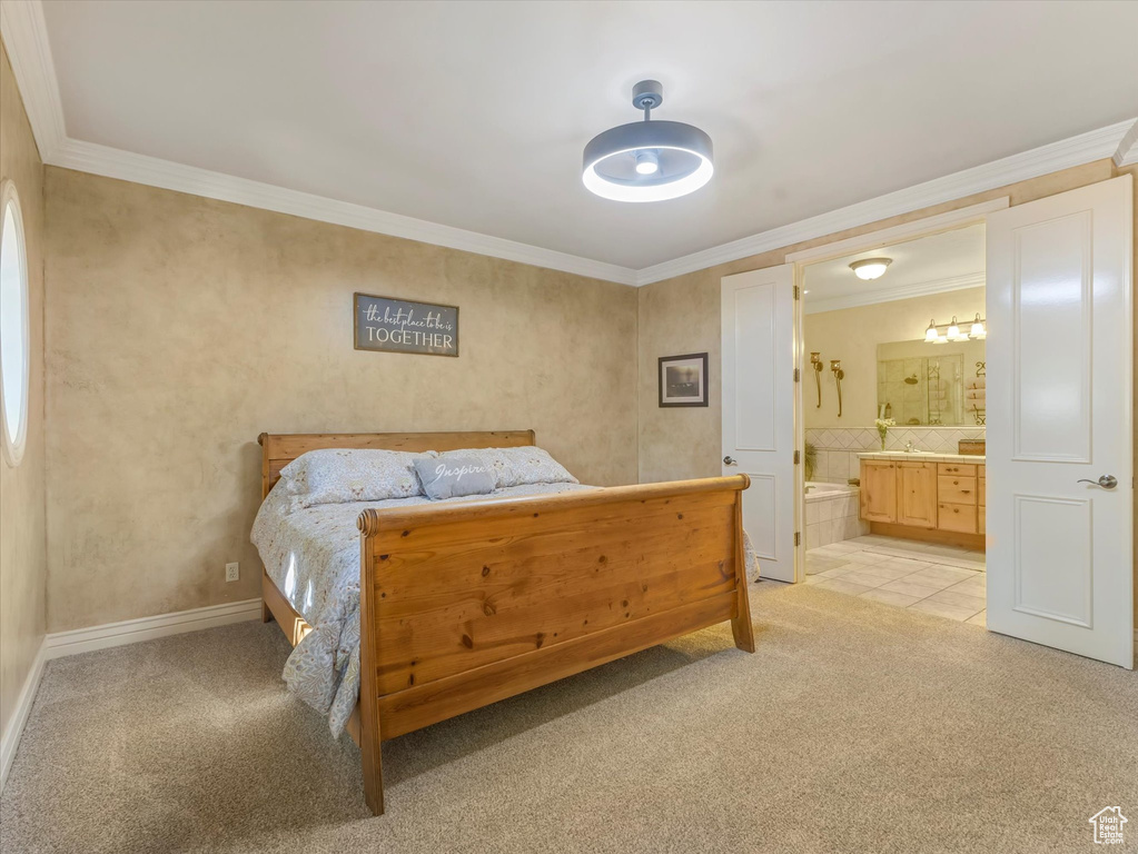 Bedroom featuring light colored carpet, crown molding, and connected bathroom