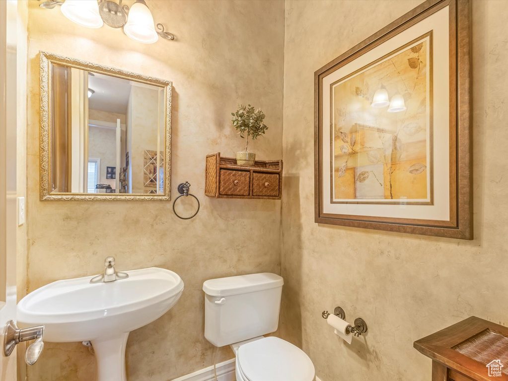 Half bath with toilet and baseboards