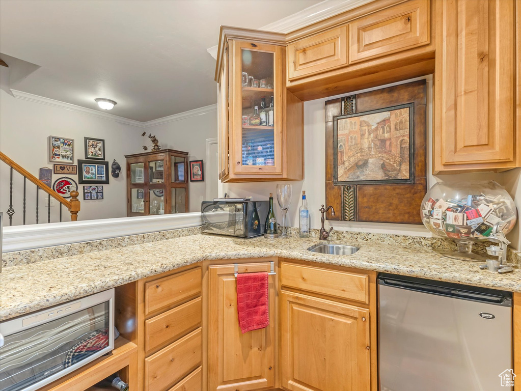 Kitchen featuring refrigerator, ornamental molding, glass insert cabinets, light stone counters, and stainless steel microwave