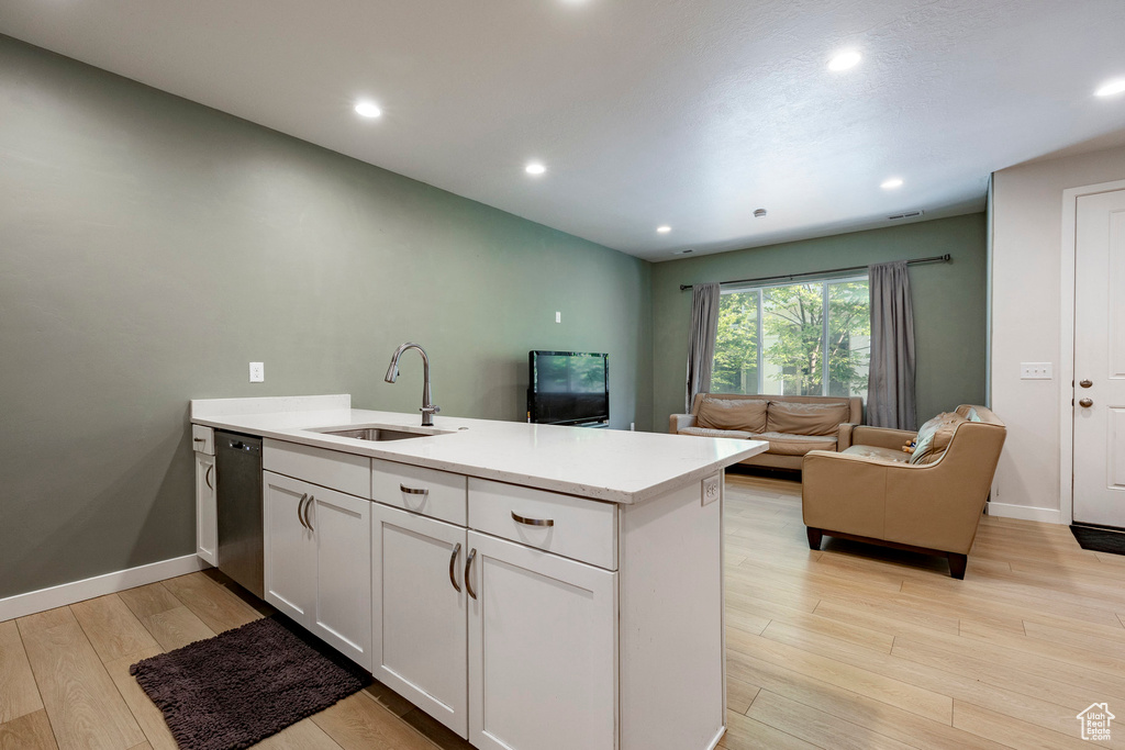 Kitchen featuring a peninsula, light wood-style floors, light countertops, white cabinetry, and recessed lighting