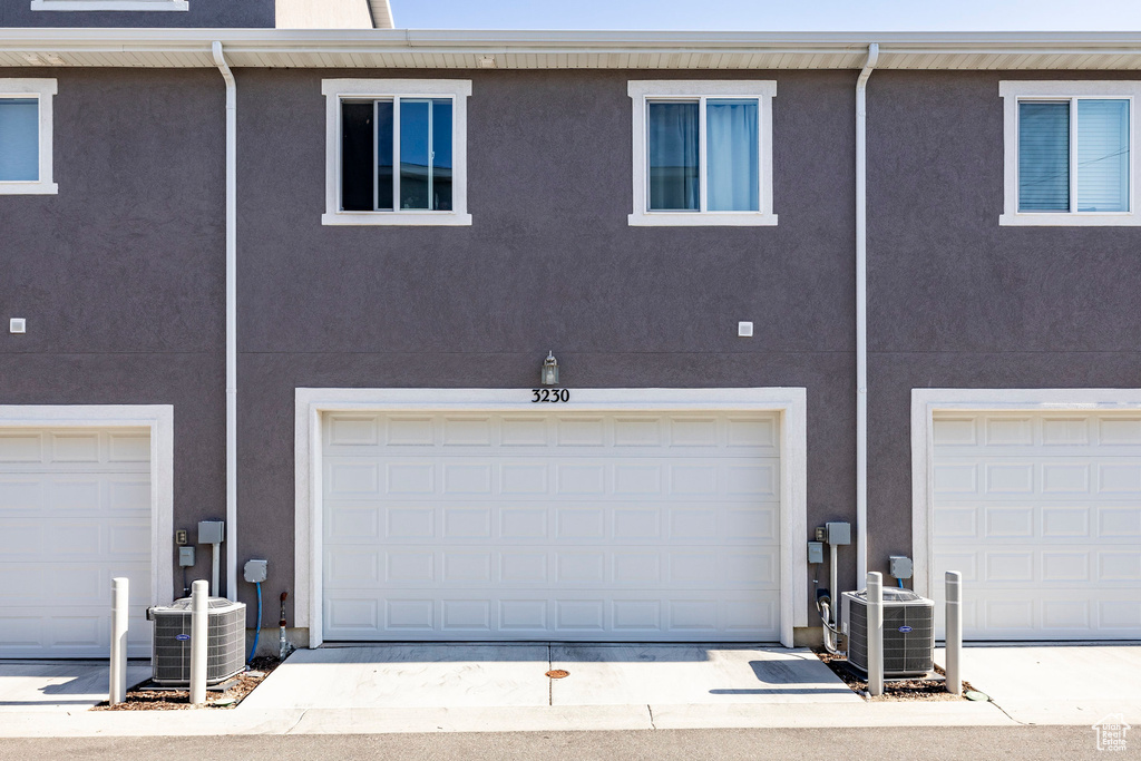 Rear view of property with stucco siding and a garage