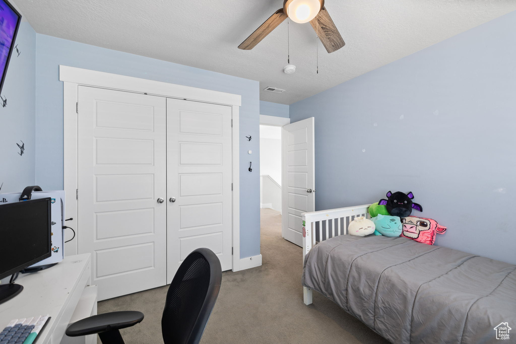 Bedroom featuring carpet, an office area, a closet, and a ceiling fan