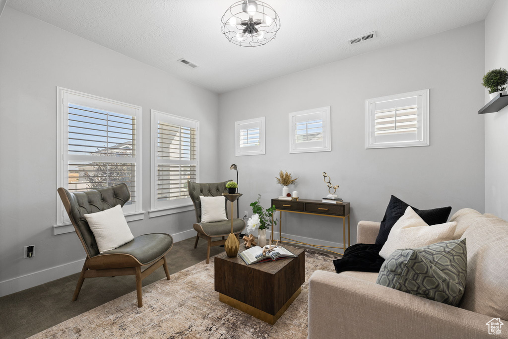 Sitting room featuring carpet and a chandelier
