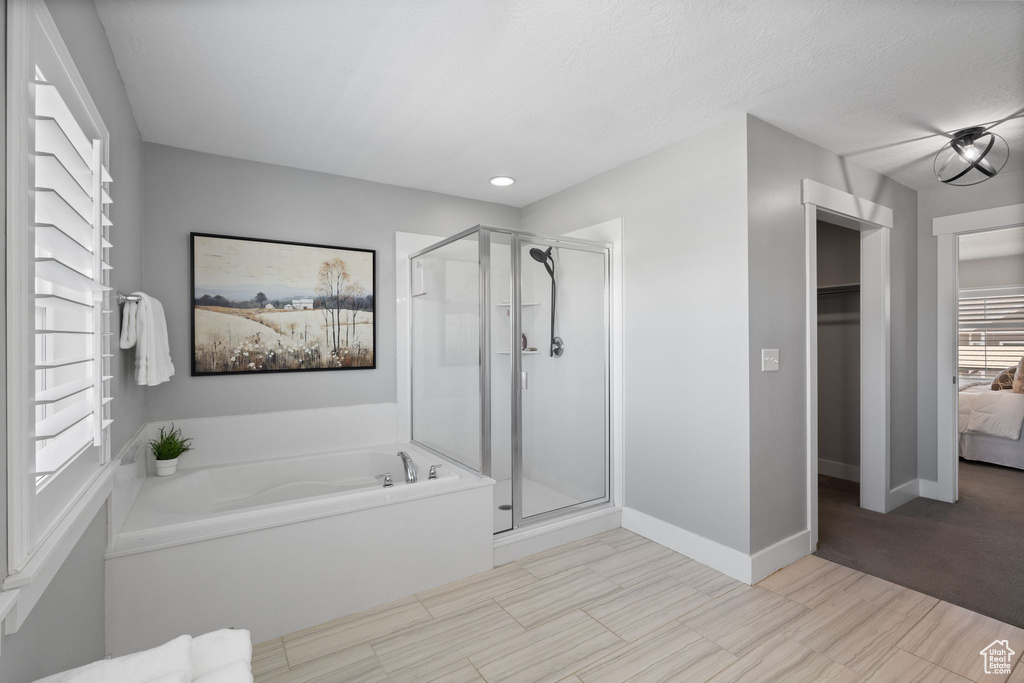 Bathroom featuring a stall shower, a bath, and recessed lighting