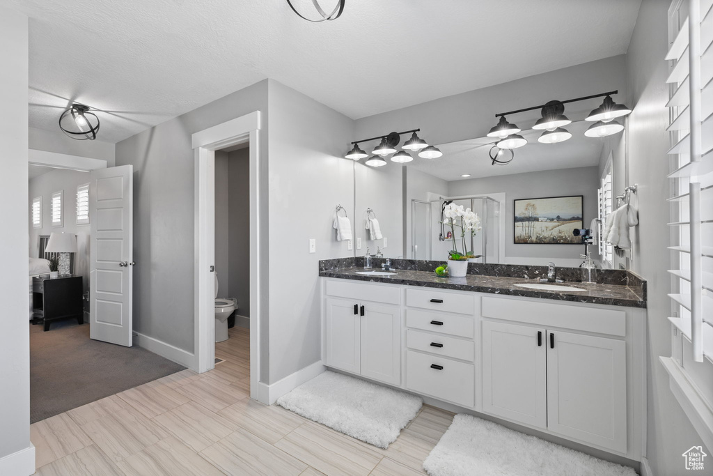 Bathroom featuring double vanity and ensuite bathroom