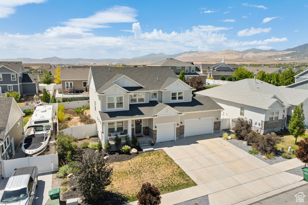 View of front of home with a residential view, a mountain view, covered porch, and driveway