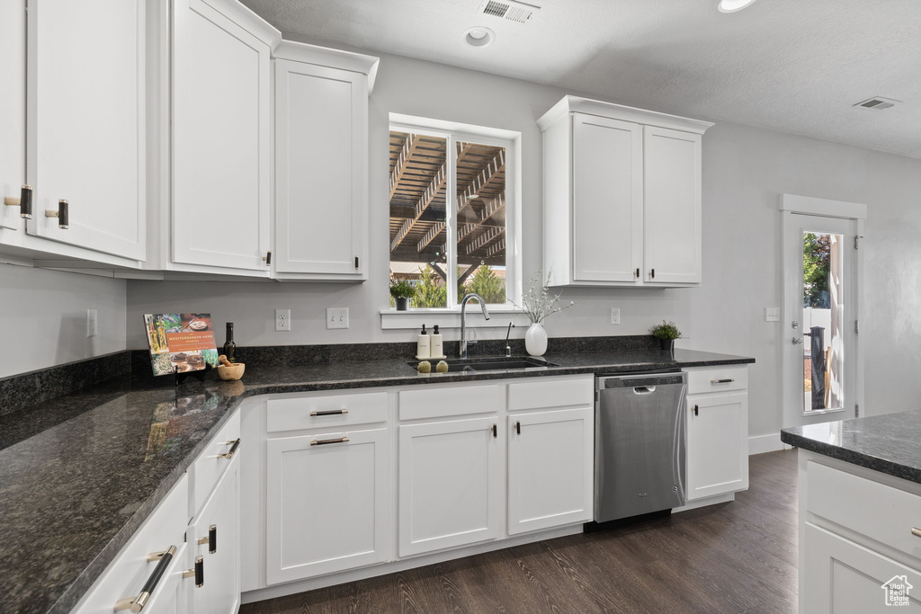 Kitchen featuring stainless steel dishwasher, dark wood-type flooring, white cabinets, healthy amount of natural light, and recessed lighting