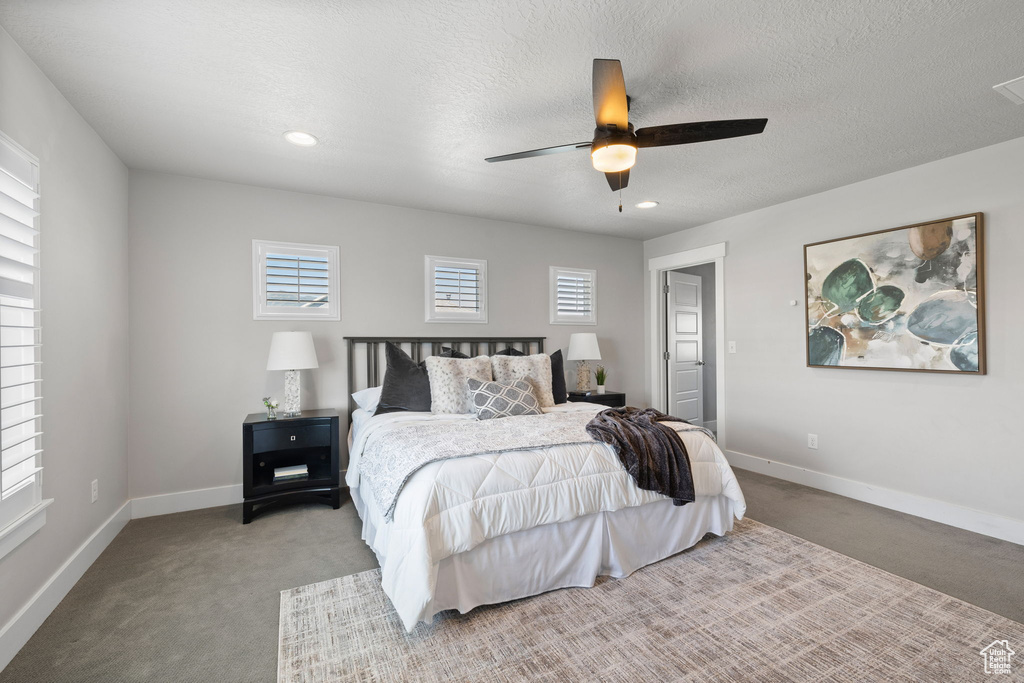 Carpeted bedroom with a ceiling fan and recessed lighting