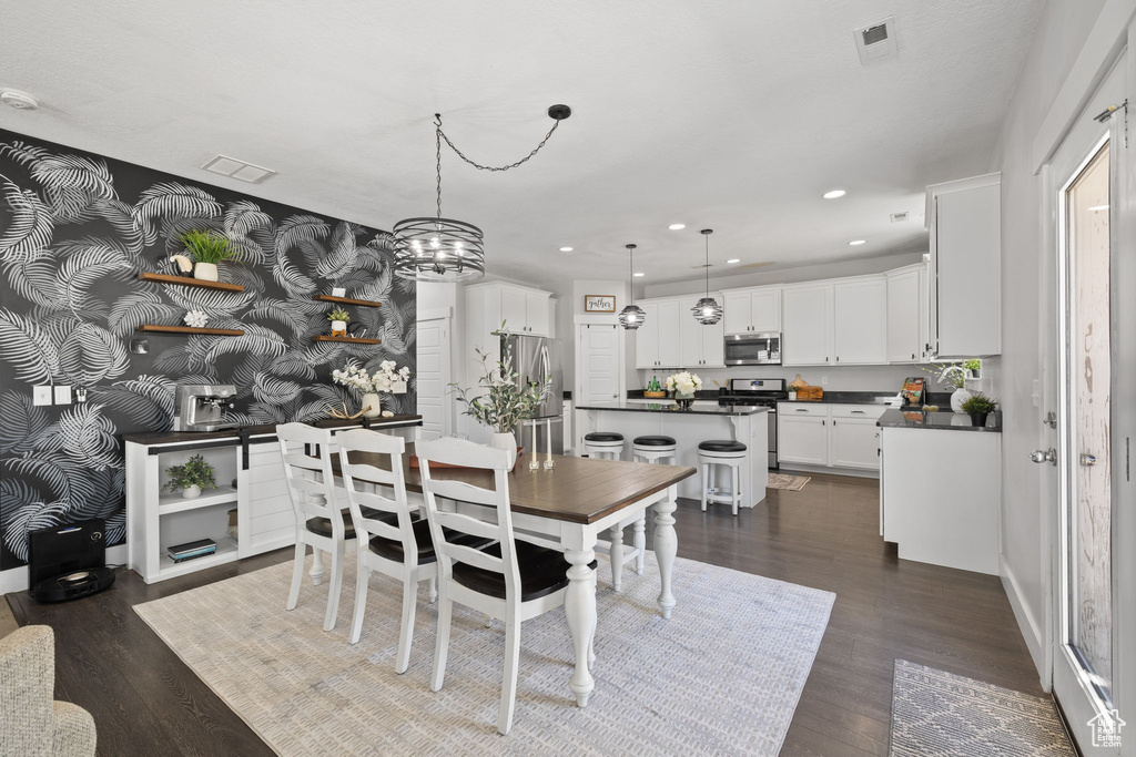 Dining space with recessed lighting, dark wood-type flooring, and a chandelier