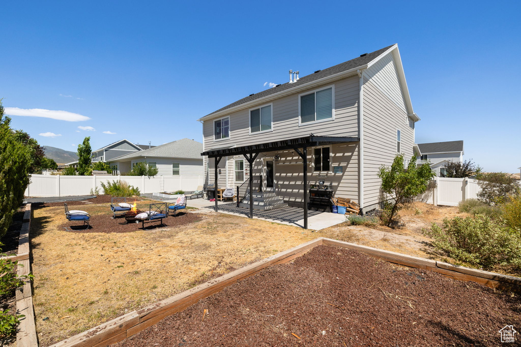 Rear view of house with a garden, a patio area, a fenced backyard, and a pergola