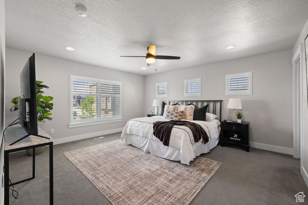 Bedroom featuring dark colored carpet, multiple windows, recessed lighting, a textured ceiling, and ceiling fan