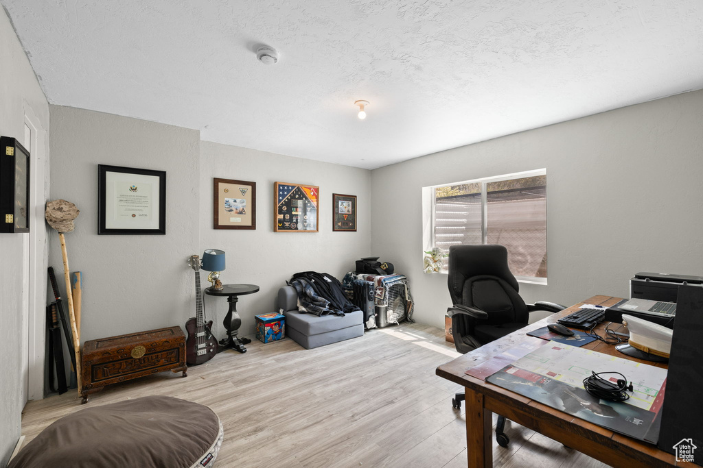 Office area with wood finished floors and a textured ceiling