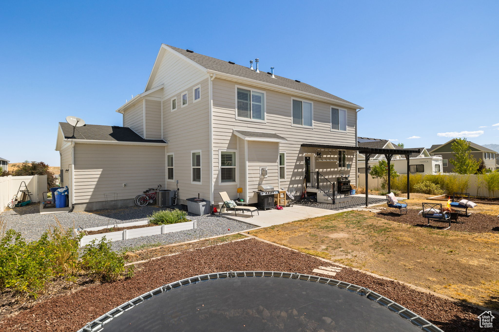 Back of property with a fire pit, a patio, and a fenced backyard