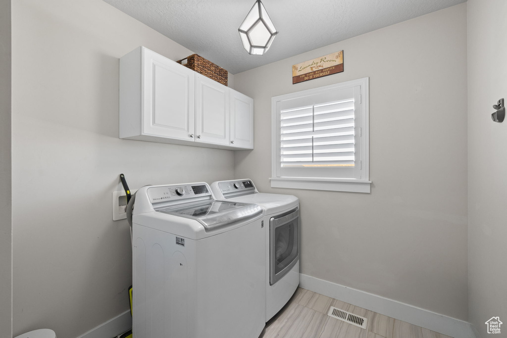 Laundry area featuring washing machine and dryer and cabinet space