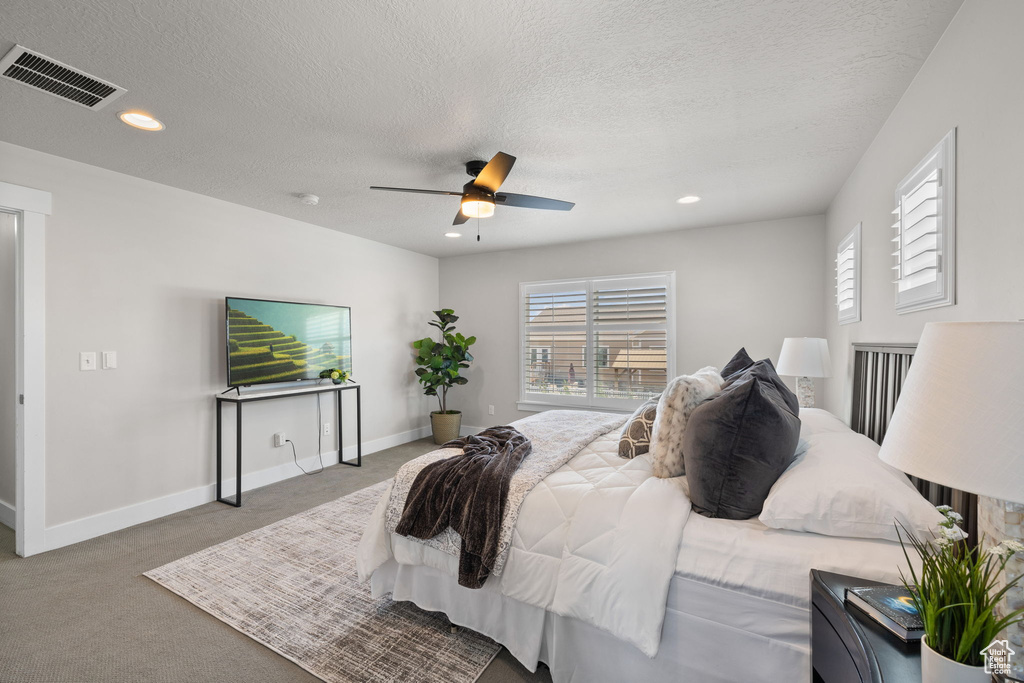 Bedroom featuring carpet, multiple windows, recessed lighting, a textured ceiling, and ceiling fan