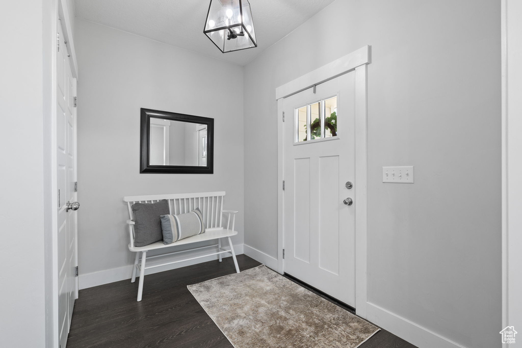 Foyer with dark wood-style floors and baseboards