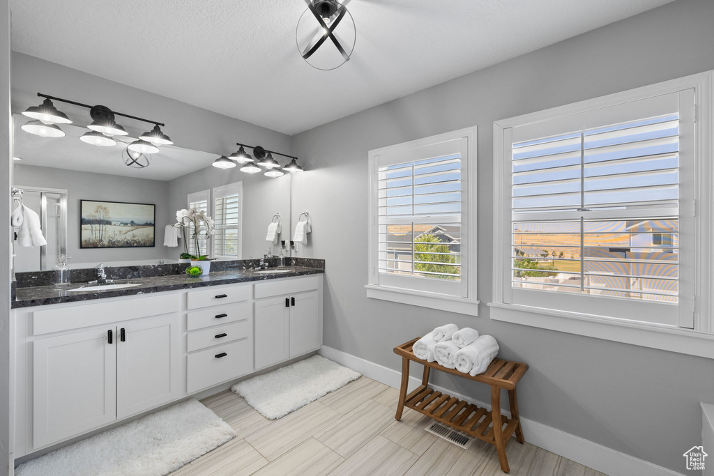 Bathroom featuring double vanity and baseboards