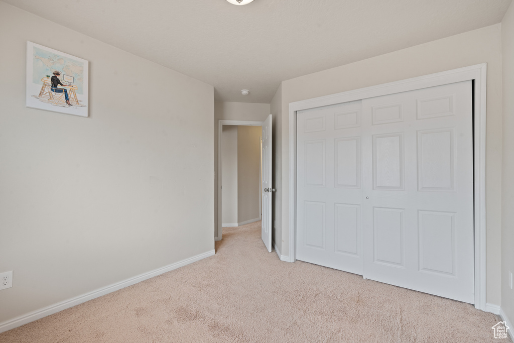 Unfurnished bedroom with carpet flooring and a closet