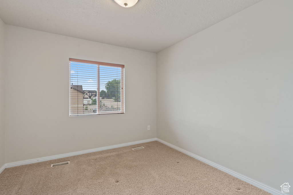 Carpeted empty room featuring baseboards