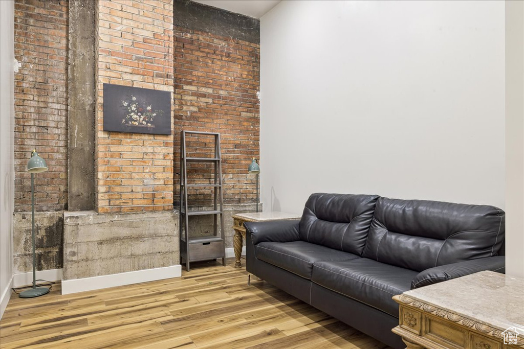 Living area featuring light wood-style flooring and brick wall