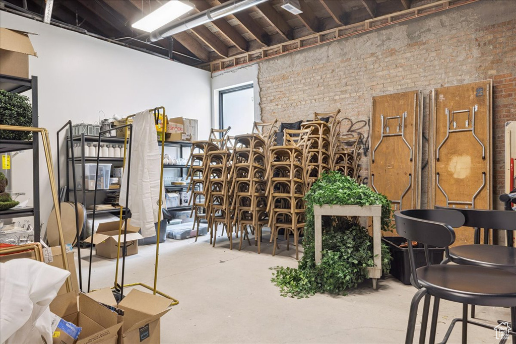 Wine area featuring brick wall and concrete floors