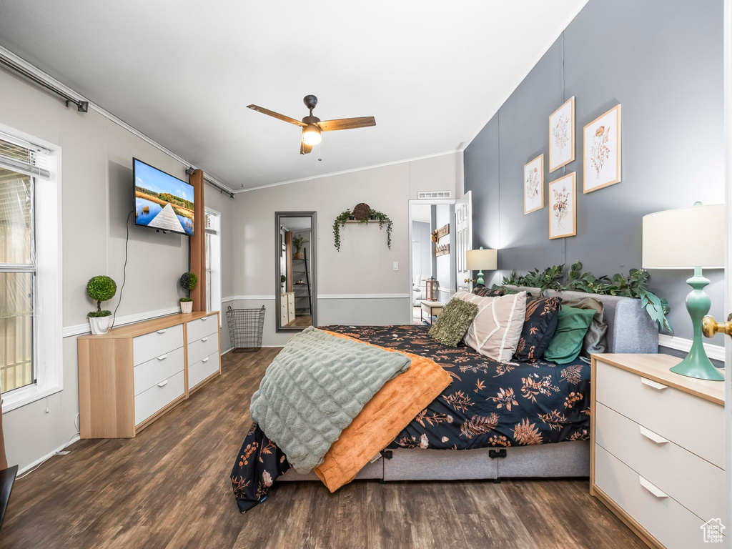 Bedroom with wood finished floors, ornamental molding, and ceiling fan
