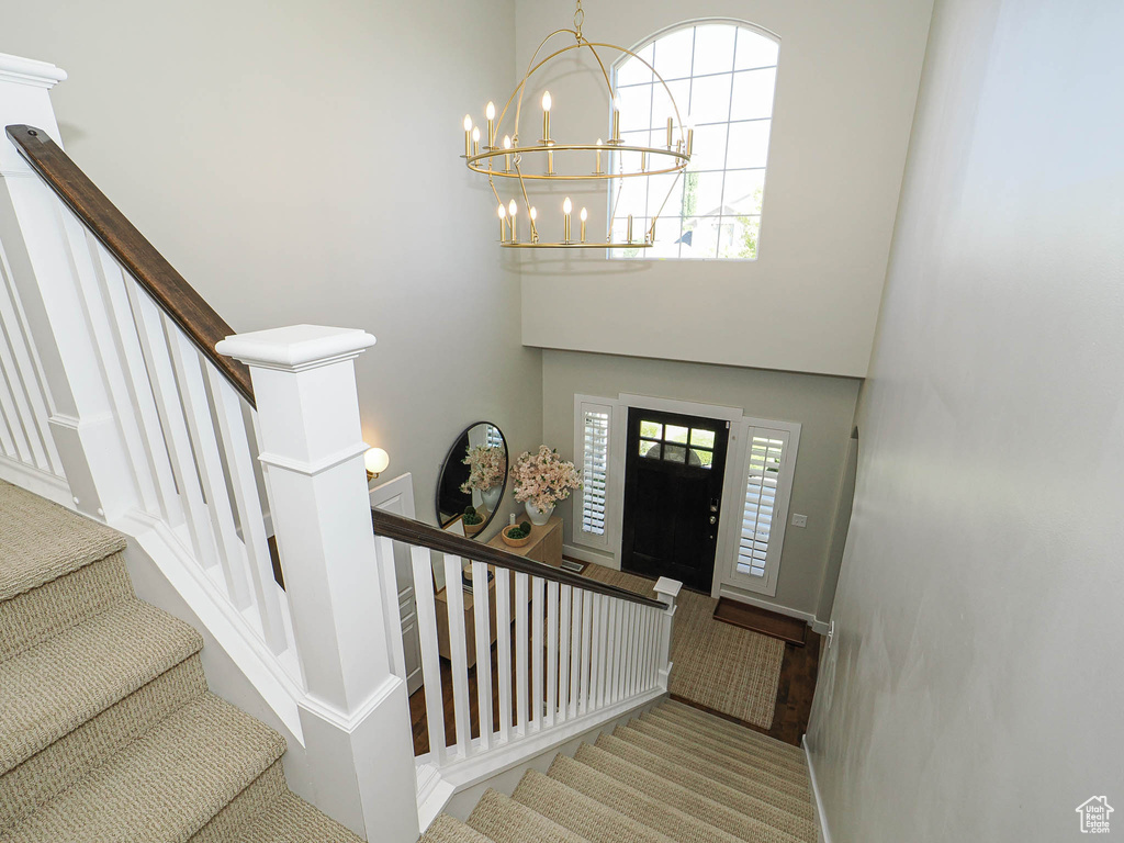 Foyer with a chandelier, stairway, and a towering ceiling