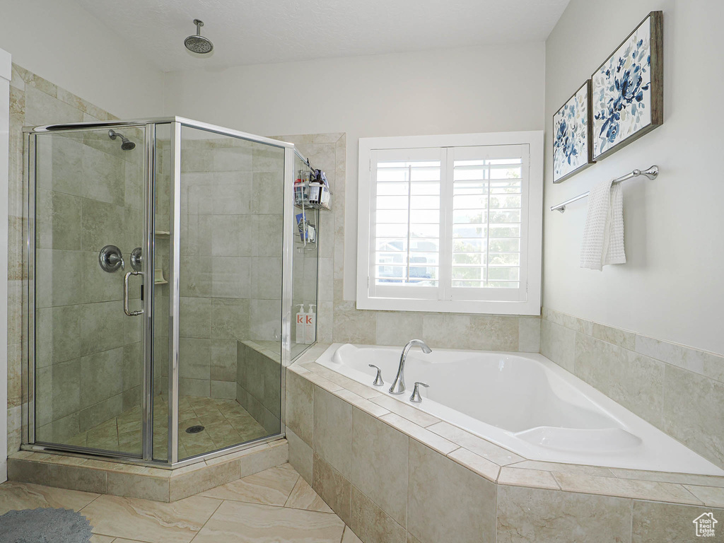 Bathroom featuring a bath and a shower stall