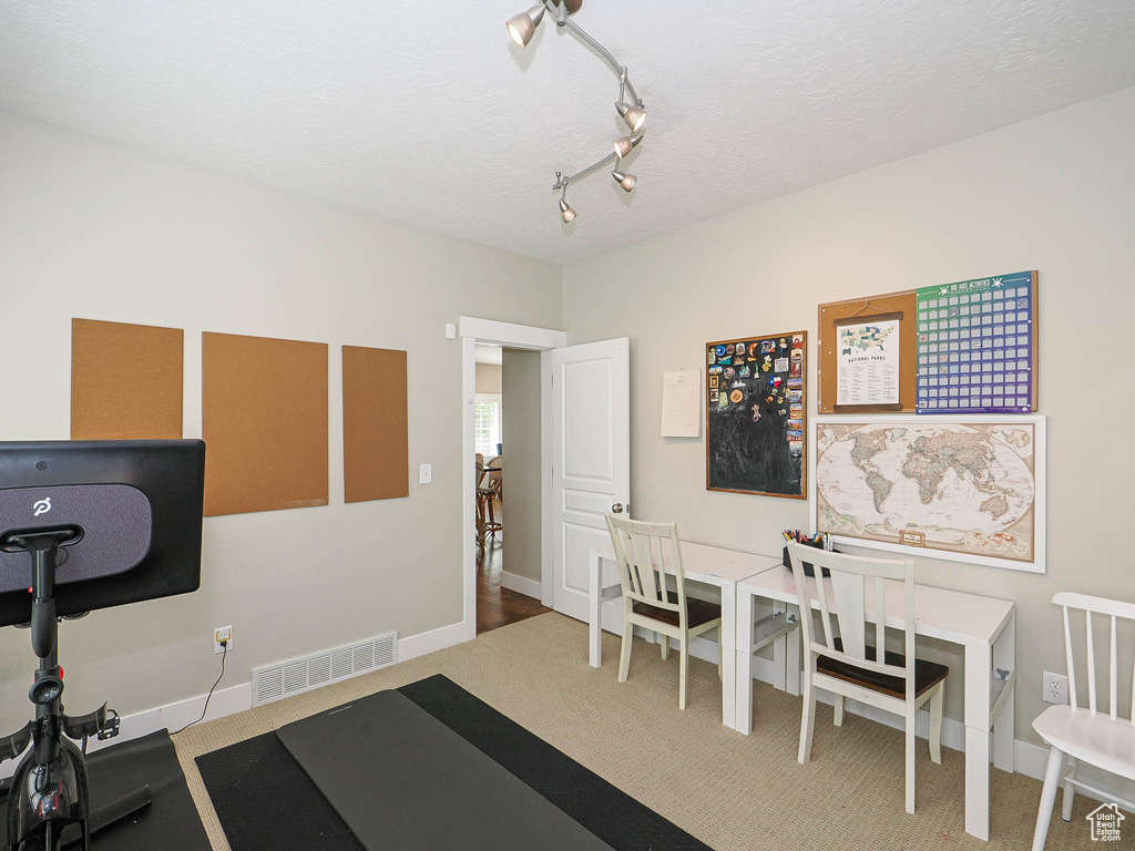 Exercise room featuring a textured ceiling and track lighting