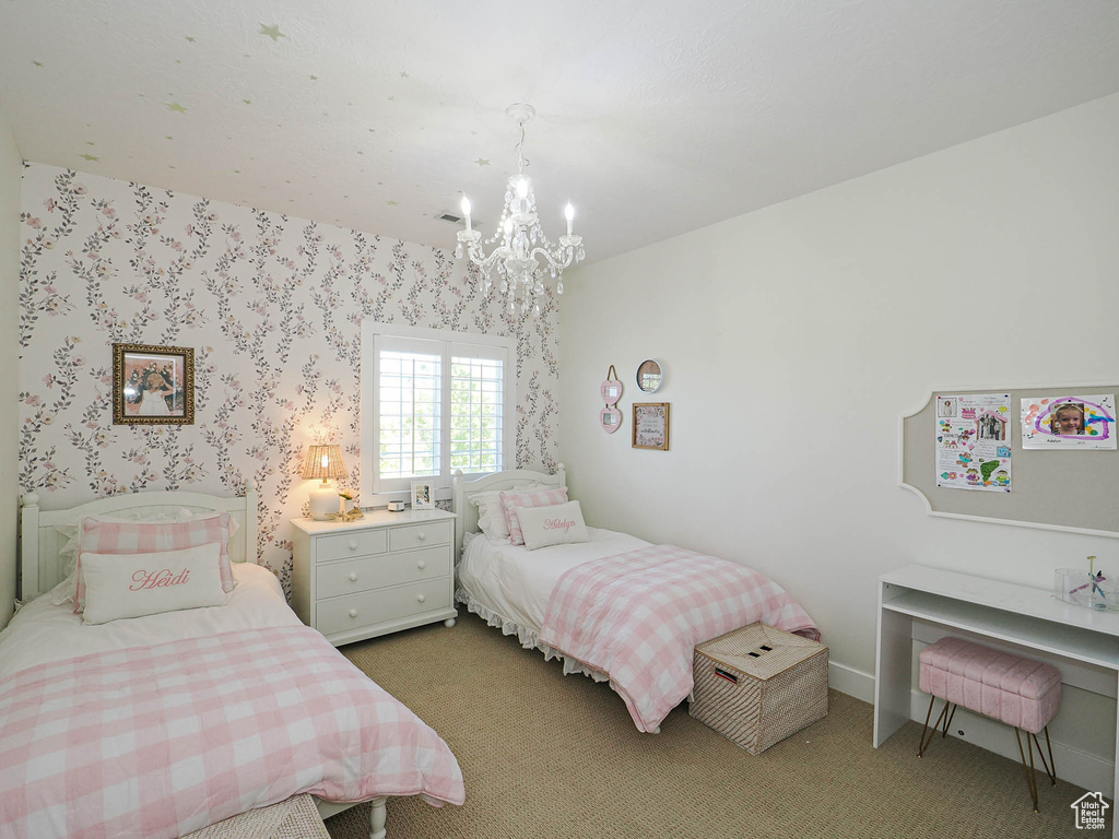 Bedroom featuring a chandelier and carpet