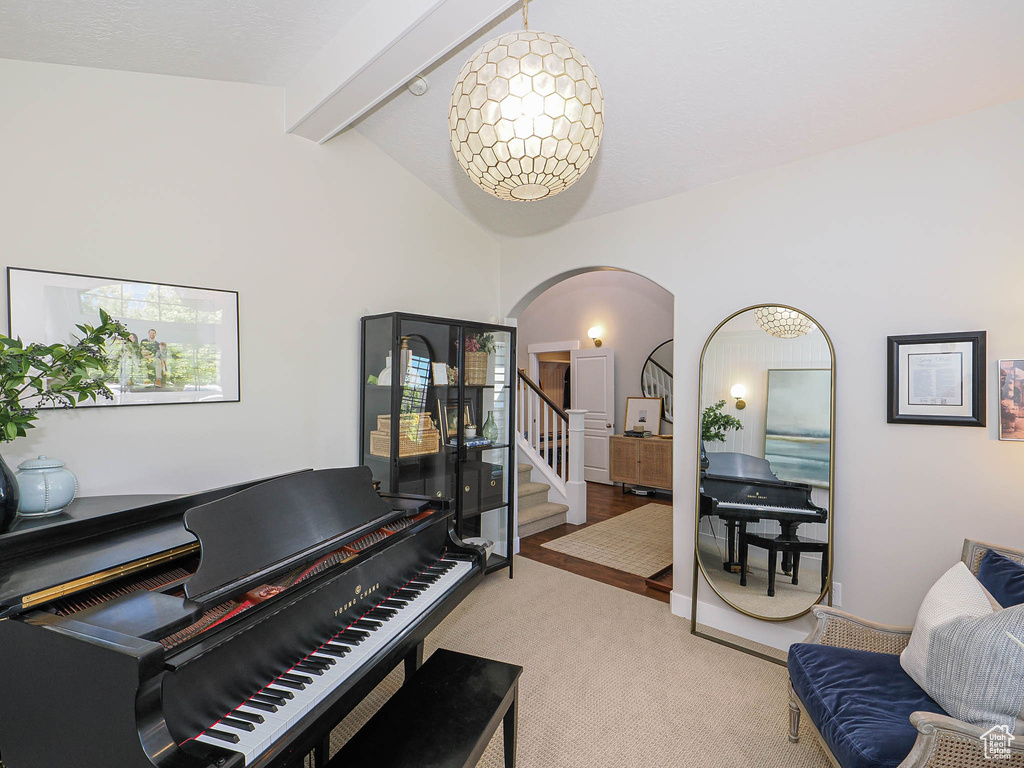 Sitting room featuring arched walkways, carpet floors, and stairs