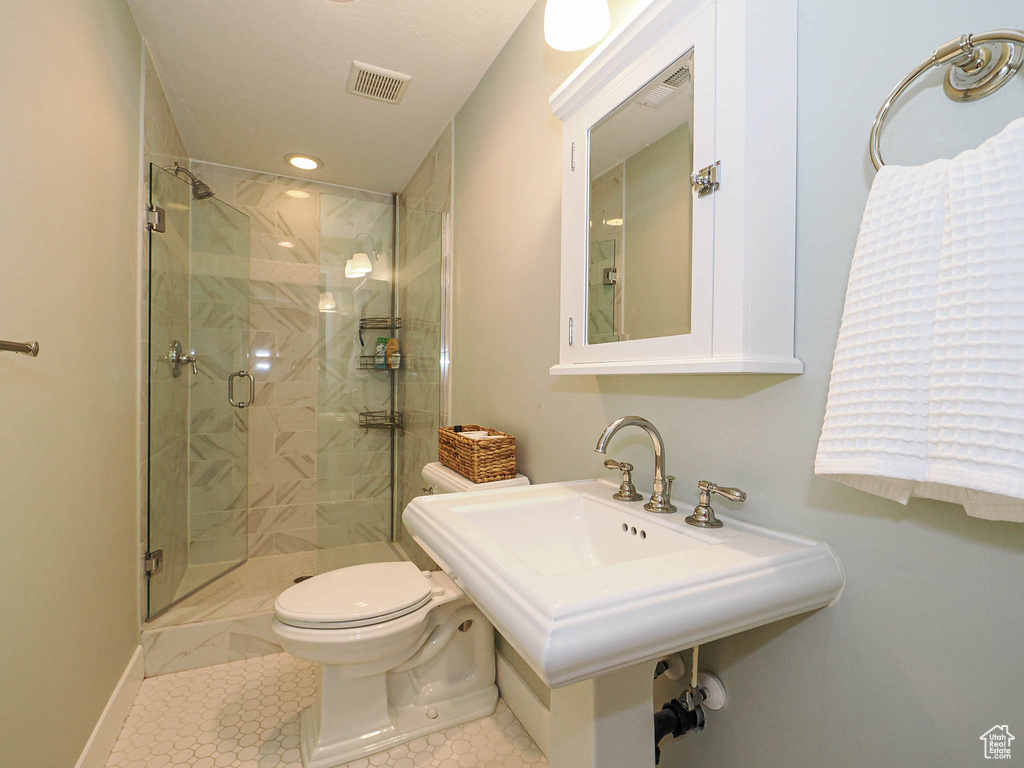 Full bath with toilet and a stall shower