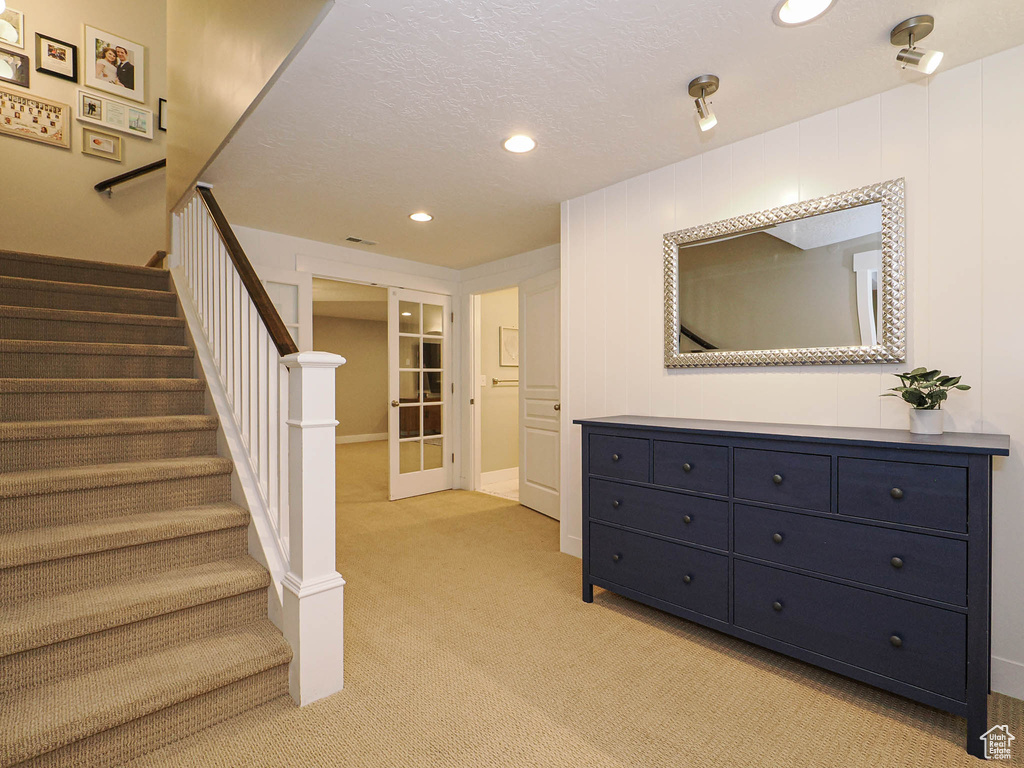 Staircase with carpet floors, french doors, recessed lighting, and a textured ceiling