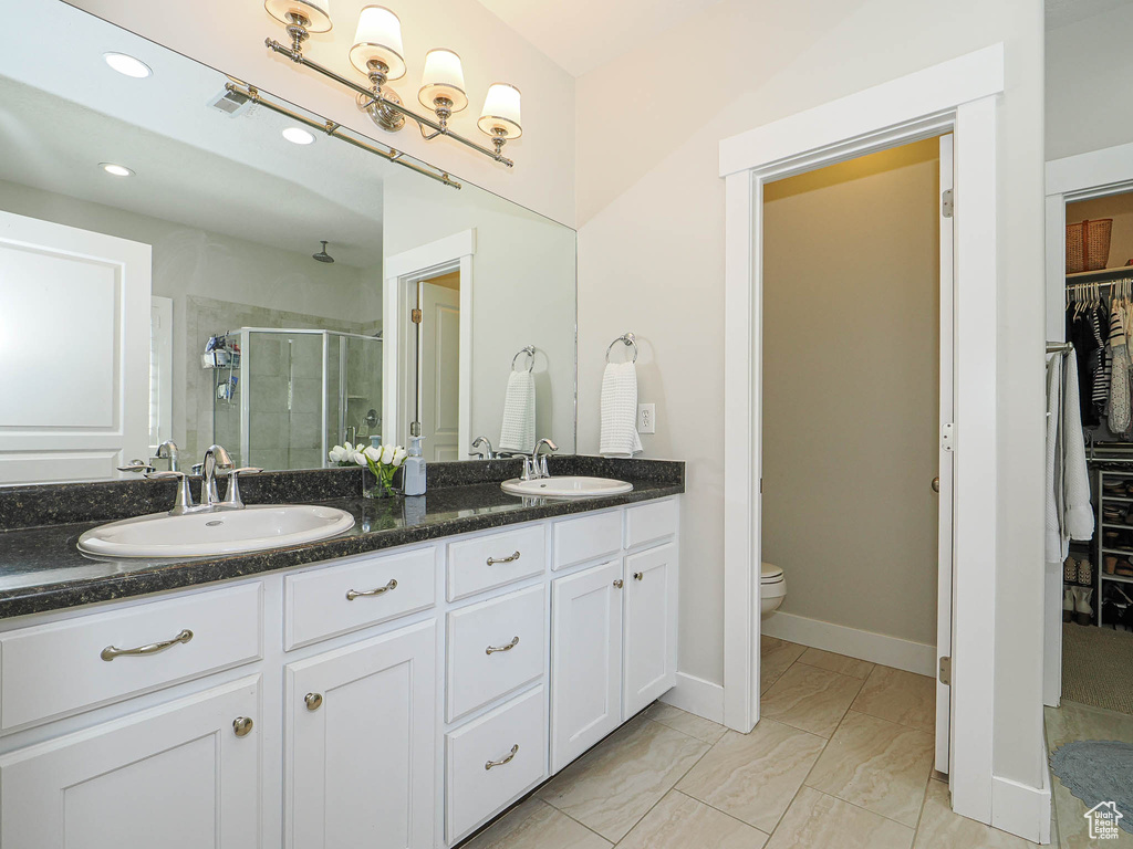 Full bathroom with a stall shower, a walk in closet, double vanity, recessed lighting, and marble look tiles