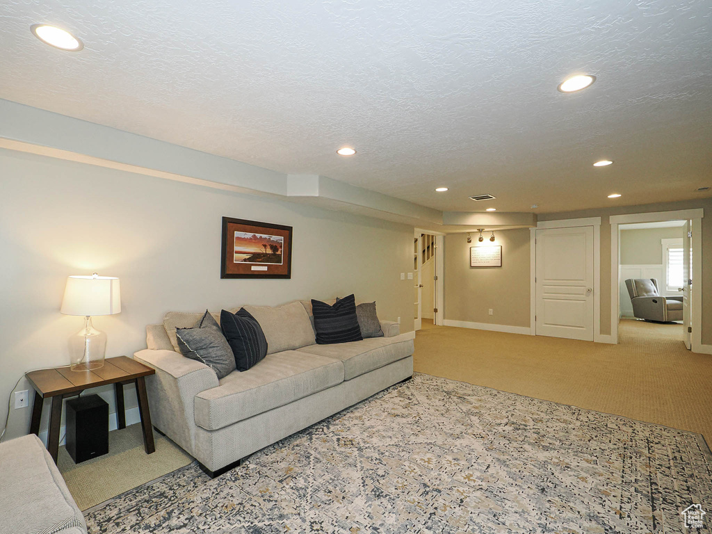 Carpeted living area featuring recessed lighting and a textured ceiling