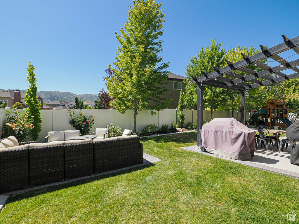Fenced backyard featuring an outdoor living space, a pergola, a mountain view, and a patio area