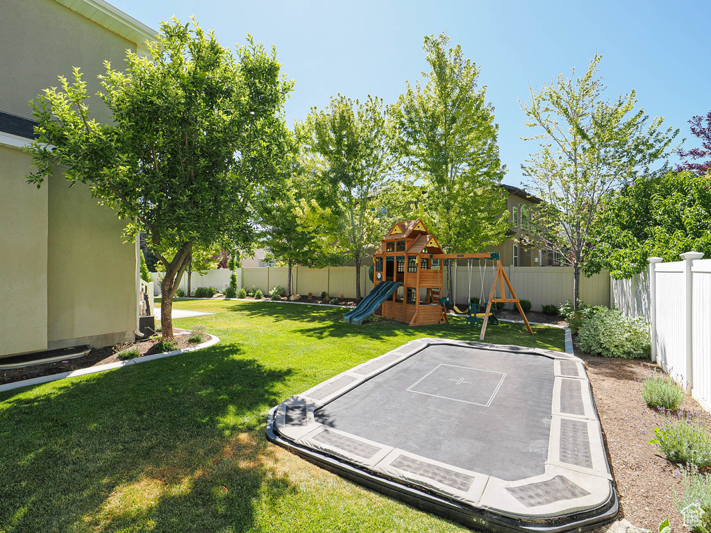 Fenced backyard featuring a playground