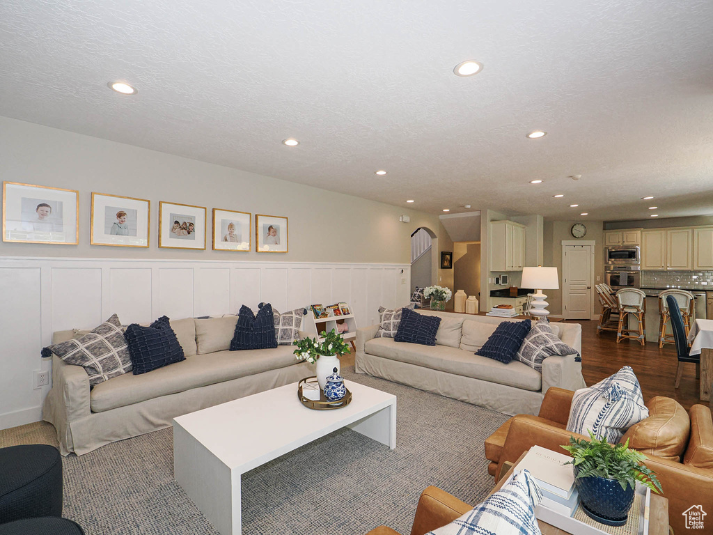 Living area featuring recessed lighting, a wainscoted wall, and dark wood finished floors
