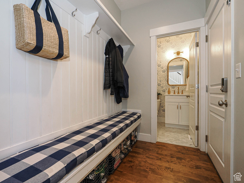 Mudroom with wood finished floors and a sink