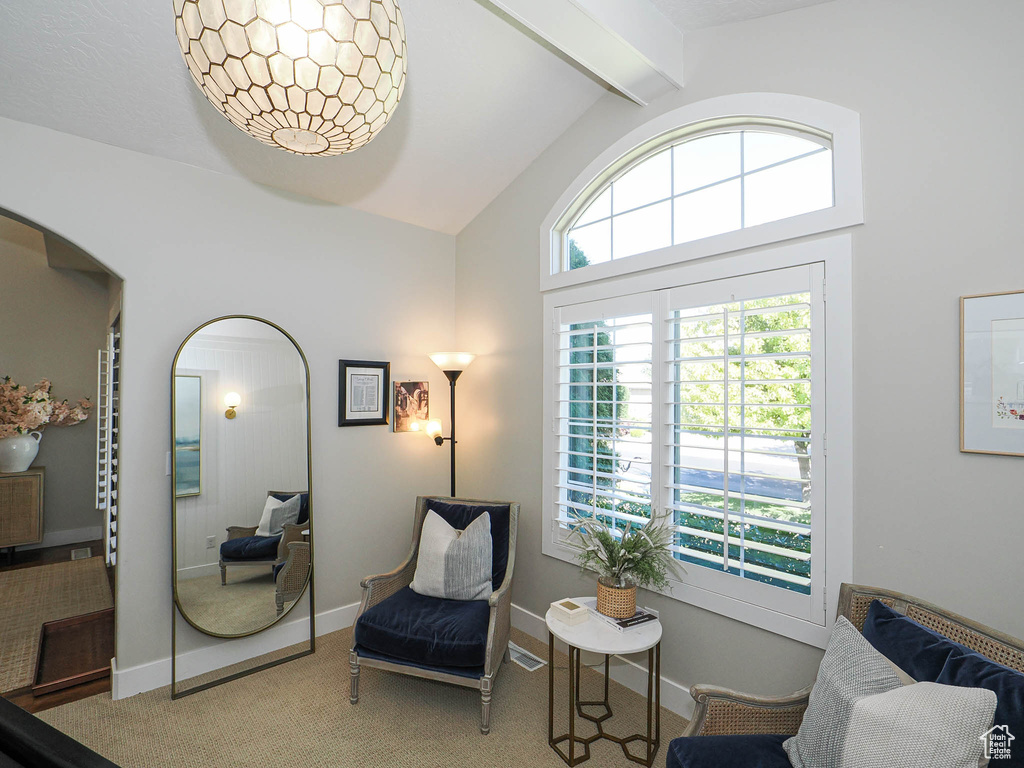 Sitting room with beam ceiling, carpet floors, arched walkways, and high vaulted ceiling
