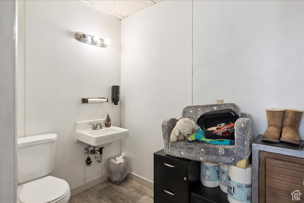 Half bath with wood finished floors and a paneled ceiling