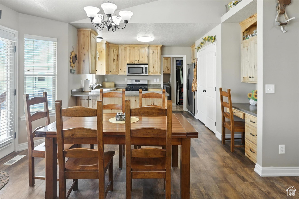 Dining area with a chandelier and dark wood-type flooring
