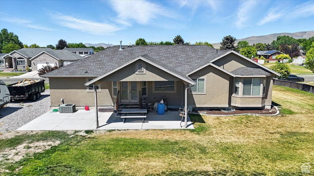 Rear view of house with french doors, stucco siding, a mountain view, and a patio area