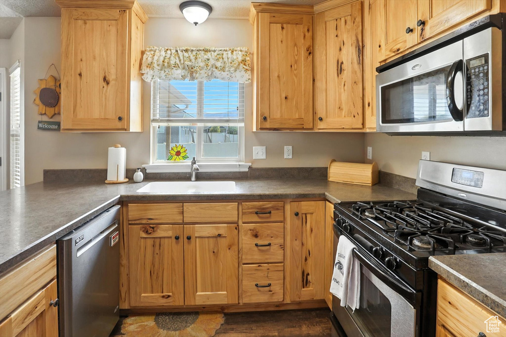 Kitchen featuring appliances with stainless steel finishes and dark countertops