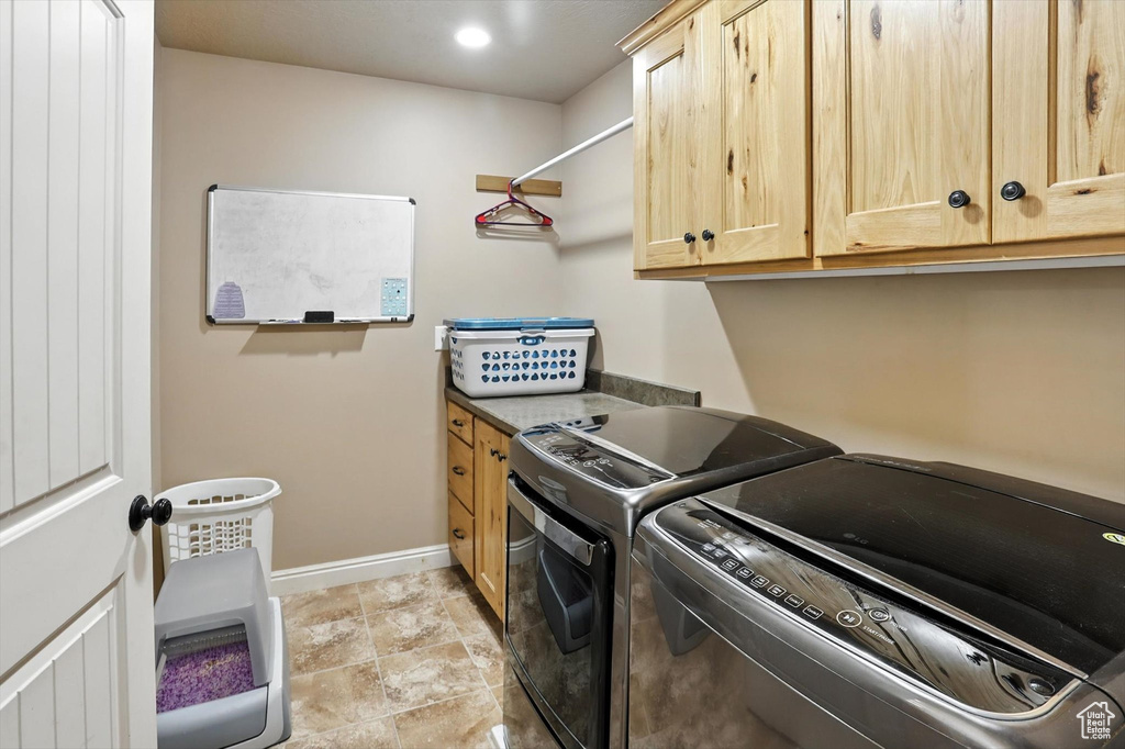 Laundry area featuring separate washer and dryer and cabinet space