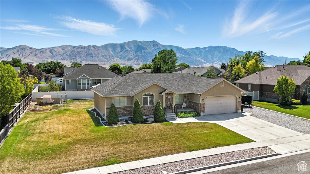 View of front of home featuring stucco siding, an attached garage, driveway, a mountain view, and a residential view