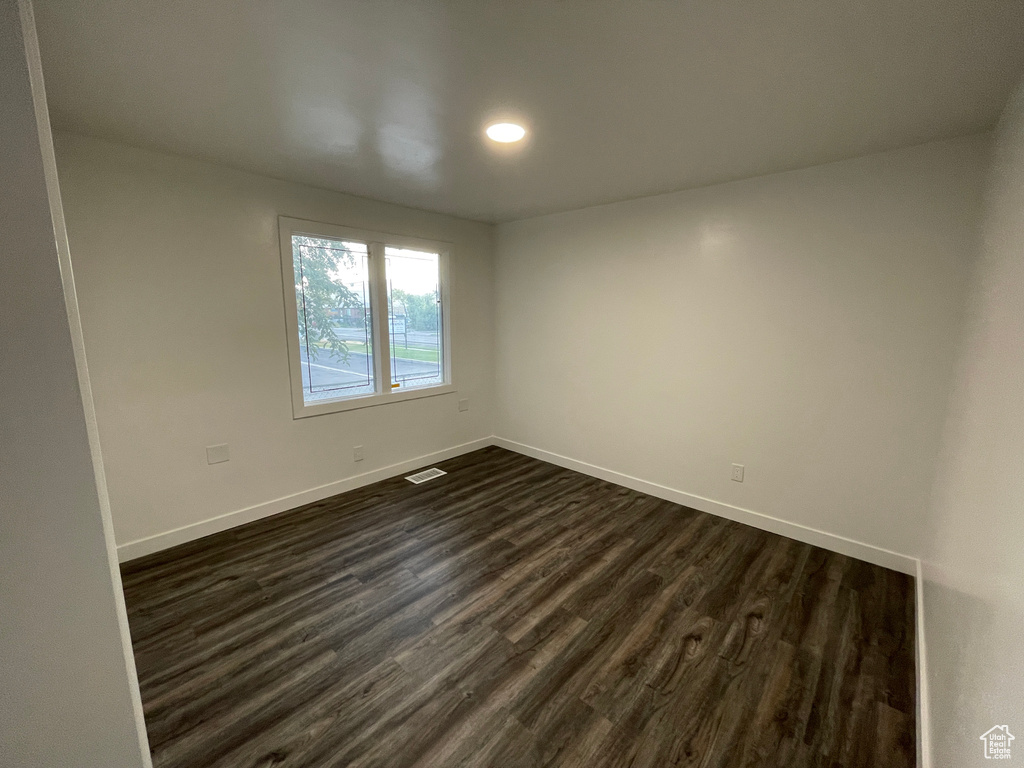 Spare room with dark wood-type flooring and recessed lighting