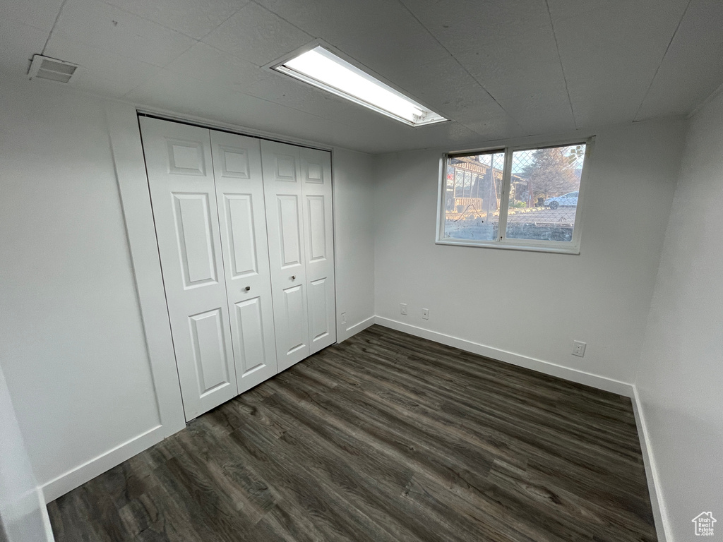 Unfurnished bedroom with dark wood-type flooring and a closet